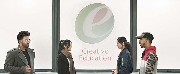 Students standing in front of the main window under the school logo